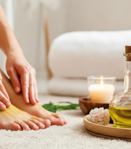 Person applying oil to feet in relaxing spa setting